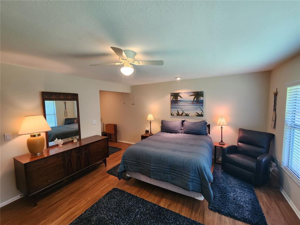 948 North Beneva Road, Unit V25 Sarasota, FL 34232 - Photo 5 of 29 a bedroom with a bed a couch and potted plant on dresser