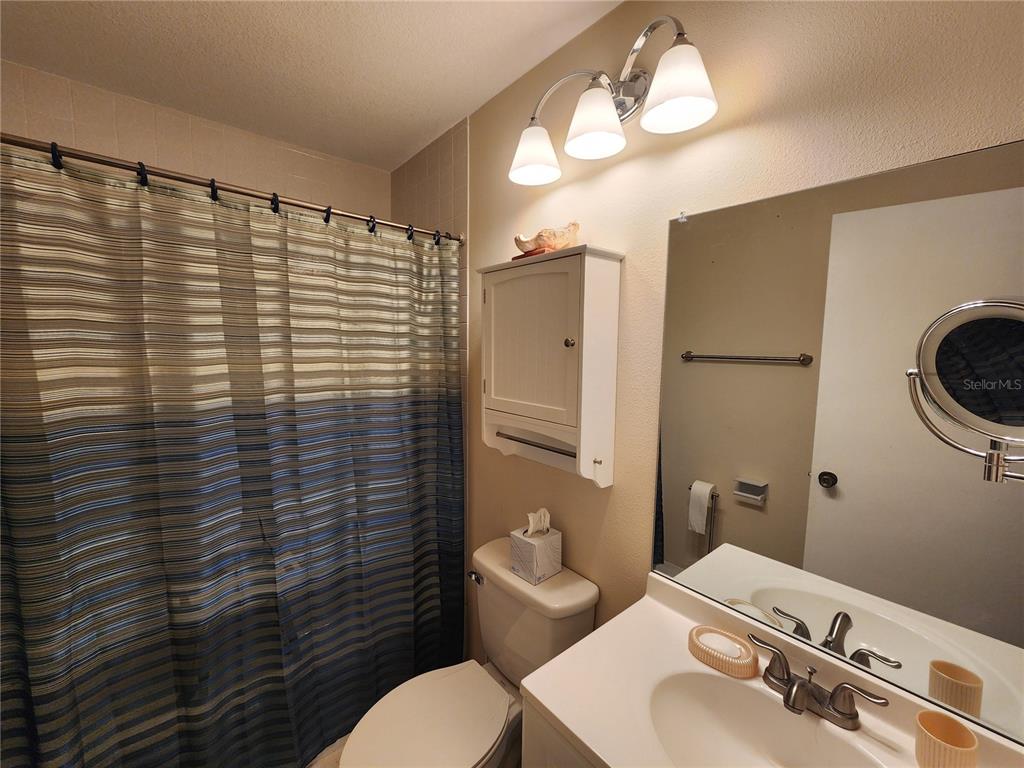 948 North Beneva Road, Unit V25 Sarasota, FL 34232 - Photo 8 of 29 a bathroom with a sink a toilet and shower curtain