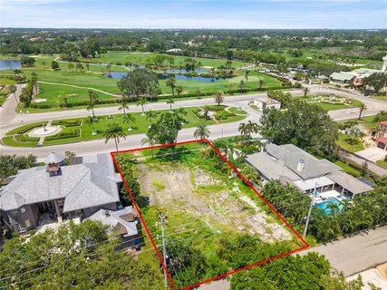 an aerial view of residential houses with outdoor space and trees