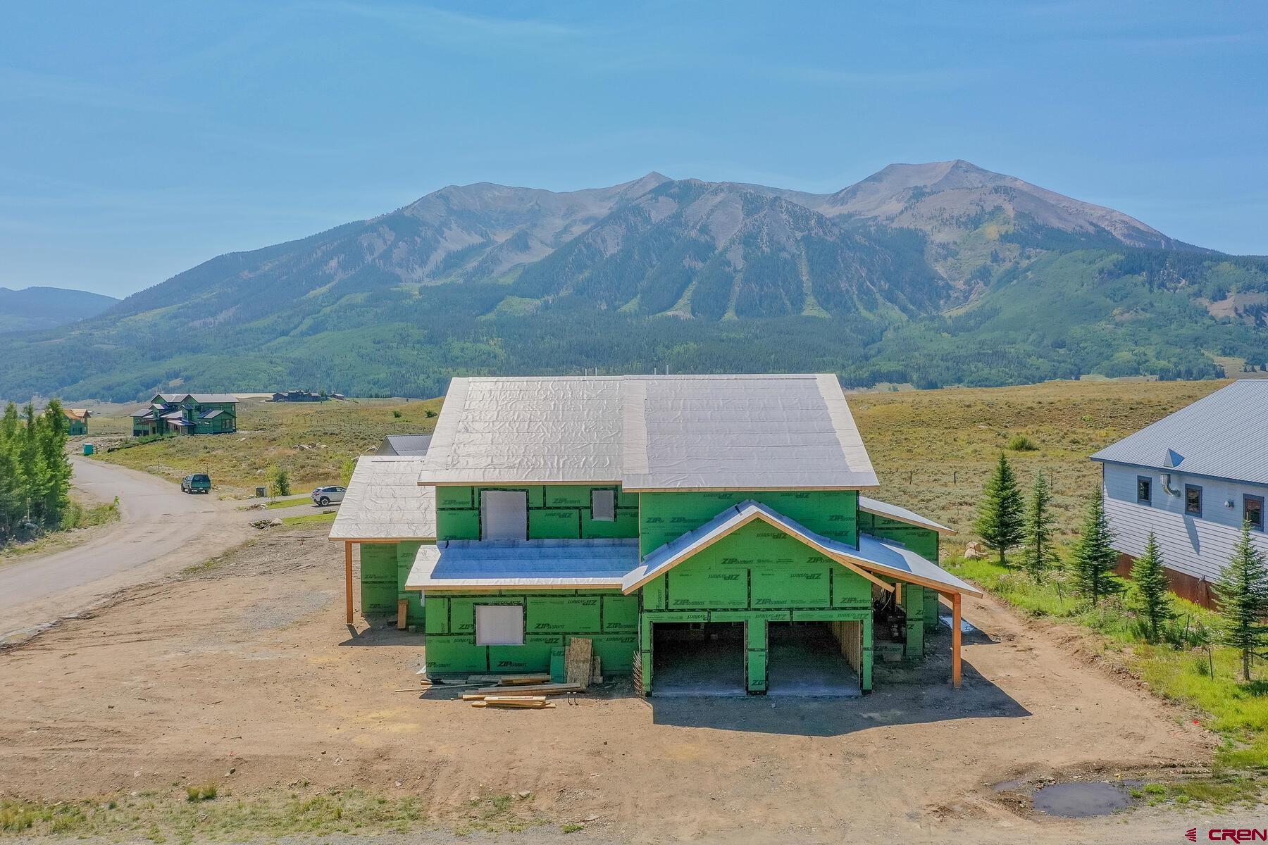 34 Elk Valley Road Crested Butte, CO 81224 - Photo 3 of 24 a front view of a house with yard and mountain view