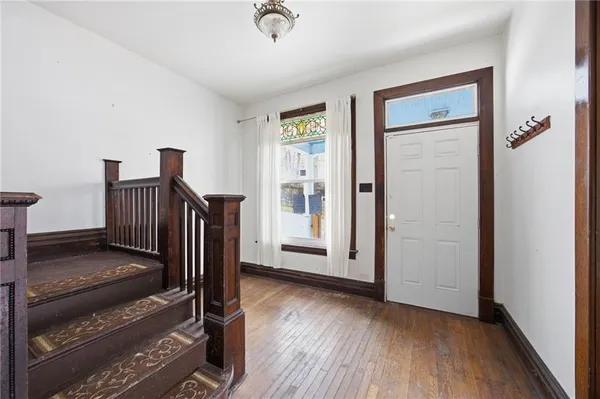 a view of a hallway with wooden floor and stairs