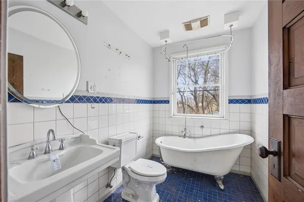 a bathroom with a sink and mirror with toilet