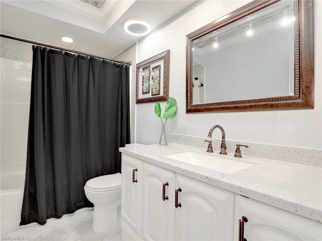 4230 Jack Frost Court, Unit 7 Naples, FL 34112 - Photo 17 of 23 a bathroom with a sink a toilet a mirror and shower