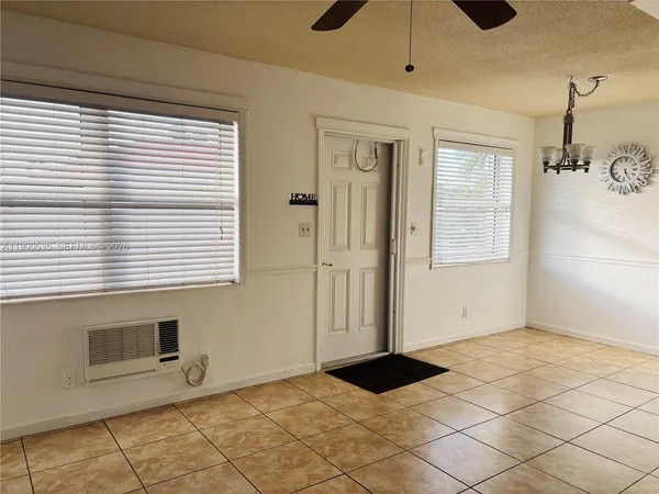 a view of an empty room with window and cabinet
