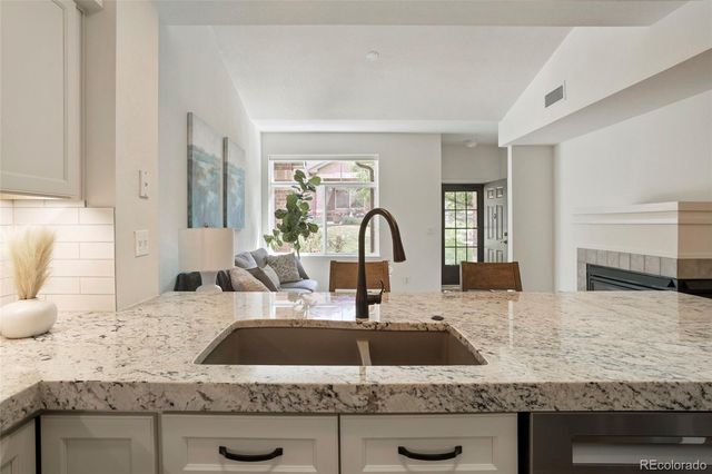 a kitchen with granite countertop a sink and a stove top oven