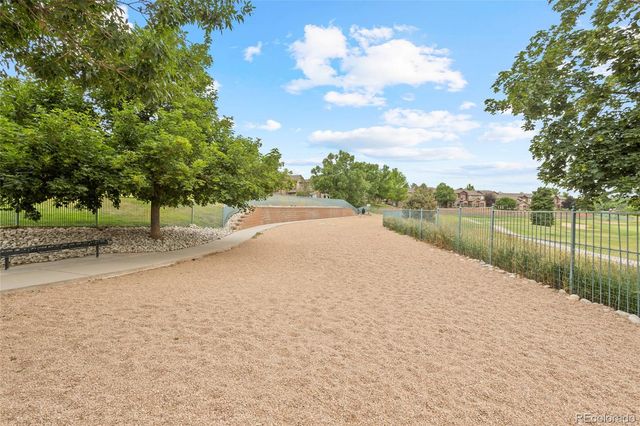 a view of a garden with a fountain and large trees