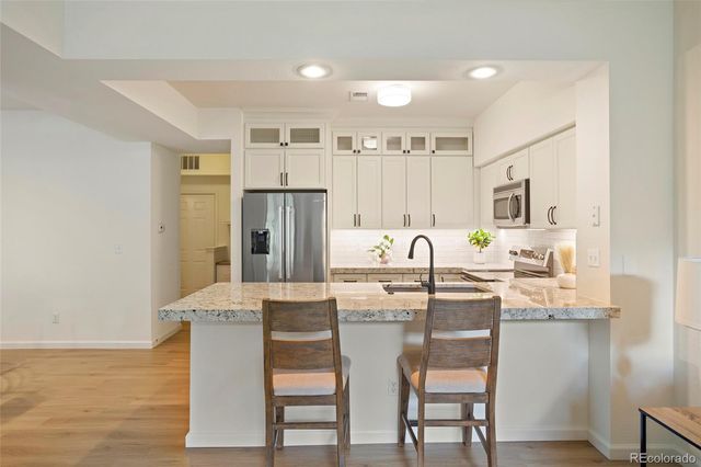 a kitchen with white cabinets and stainless steel appliances