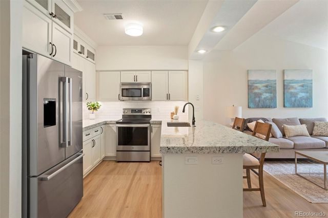 a kitchen with stainless steel appliances granite countertop a refrigerator stove microwave and sink