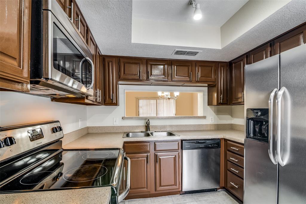 a kitchen with stainless steel appliances granite countertop a stove a sink and a microwave