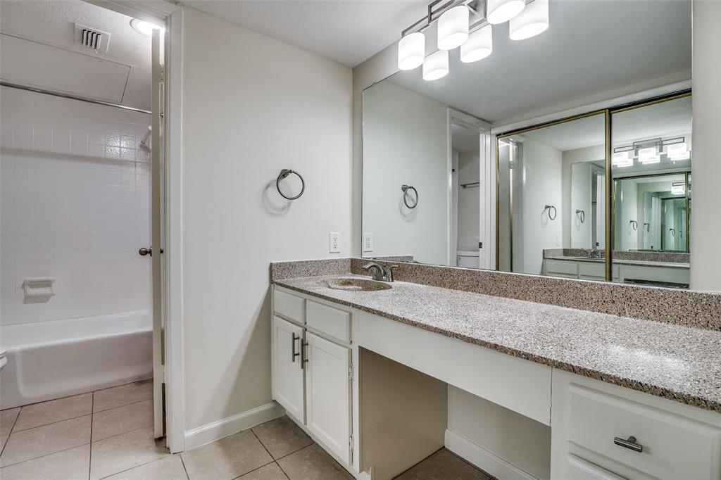 4535 North O'Connor Road, Unit 1218 Irving, TX 75062 - Photo 11 of 12 a bathroom with a granite countertop sink a large mirror and a bathtub
