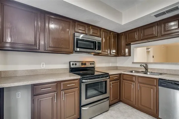 a kitchen with granite countertop cabinets stainless steel appliances and a sink