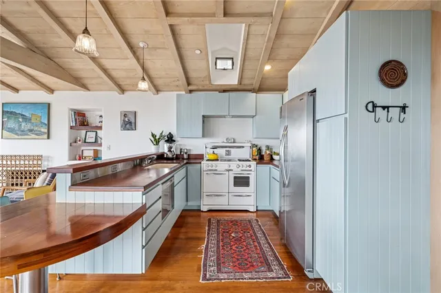 a large kitchen with stainless steel appliances granite countertop a sink and cabinets