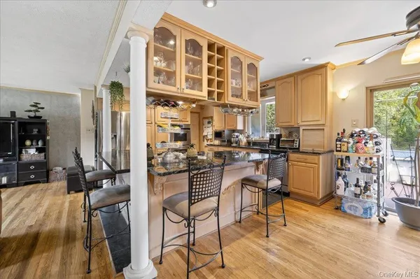 a kitchen with stainless steel appliances granite countertop a refrigerator a sink dishwasher a oven and a dining table with wooden floor