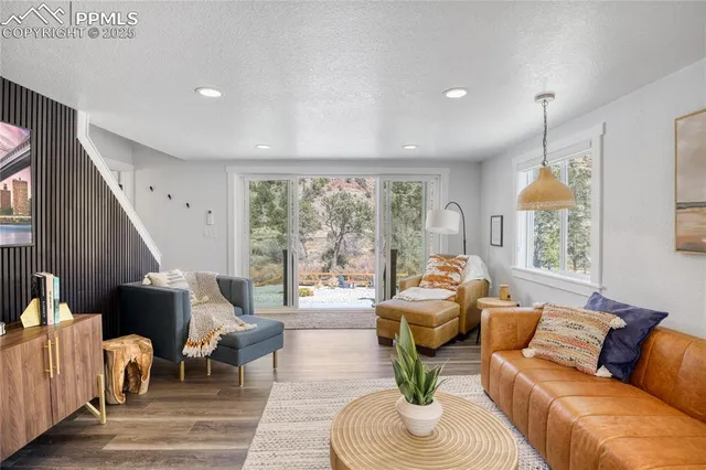 a living room with furniture fireplace and large windows