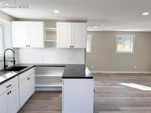 a kitchen with granite countertop a sink and cabinets