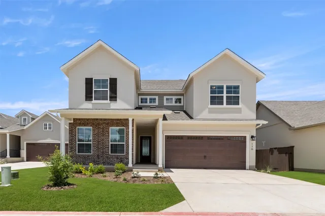a front view of a house with a yard and garage
