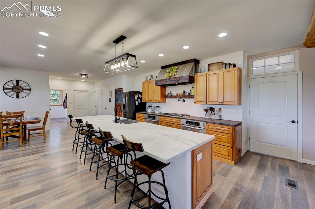 13880 Eastonville Road Elbert, CO 80106 - Photo 10 of 44 a kitchen with stainless steel appliances a dining table chairs stove and wooden floor
