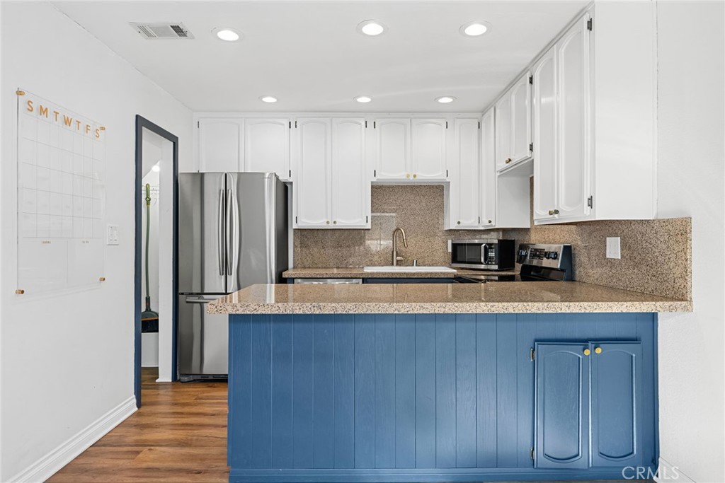 1845 Anaheim Avenue Costa Mesa, CA 92627 - Photo 3 of 13 a large kitchen with stainless steel appliances granite countertop a refrigerator a stove and a sink with wooden cabinets