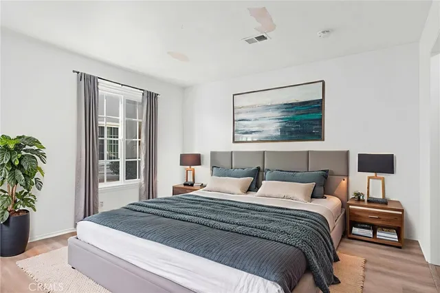 a bedroom with a large bed and a potted plant