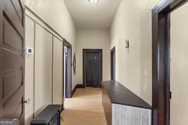 a view of a hallway with wooden floor and staircase