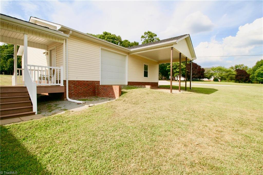 7114 Harper Ridge Court Oak Ridge, NC 27310 - Photo 27 of 28 Exterior view of siding loading garage with extra carport/overhang area.