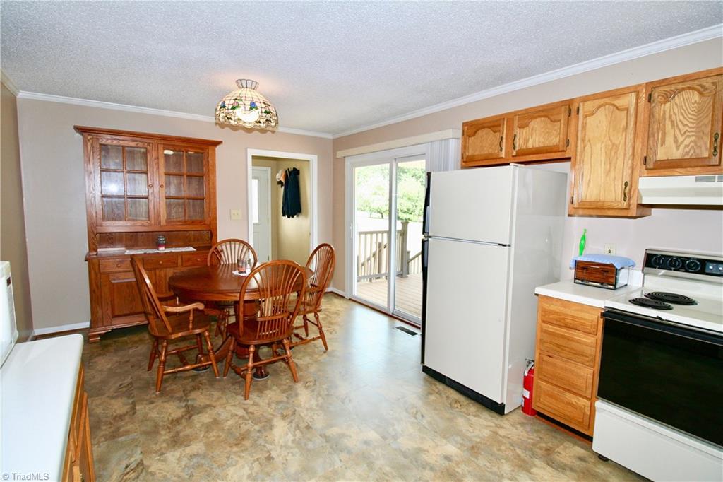 7114 Harper Ridge Court Oak Ridge, NC 27310 - Photo 8 of 28 Kitchen leads to laundry room and breezeway to garage and has sliding door access to deck!