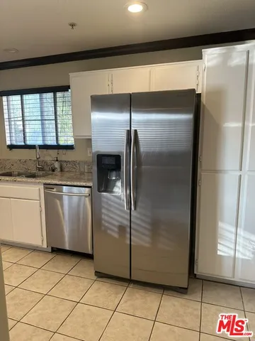 a kitchen with white cabinets and white appliances