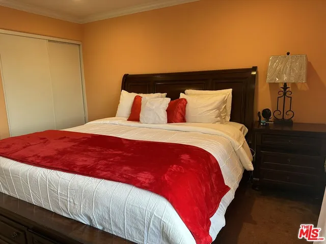 a large bed sitting in a bedroom next to a window