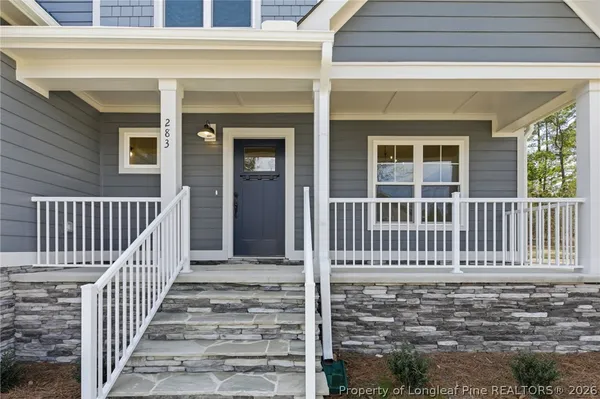 a bathroom with a granite countertop sink window and cabinets