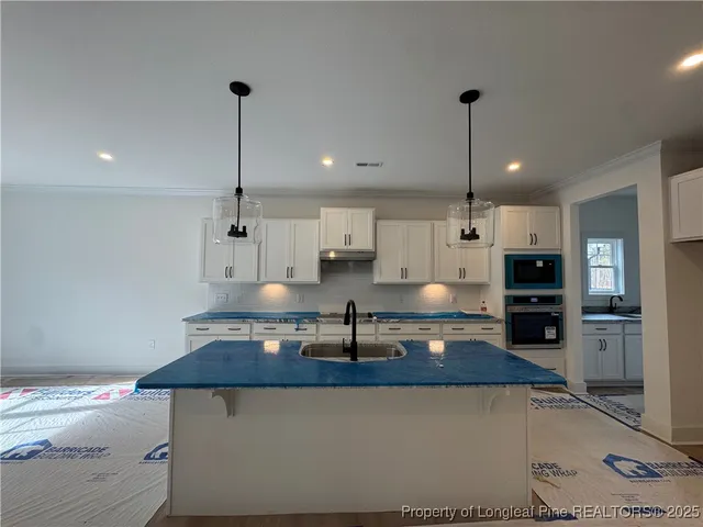 a kitchen with kitchen island a counter top space appliances and cabinets