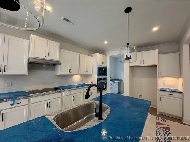 a kitchen with stainless steel appliances granite countertop a sink a stove and a wooden floors