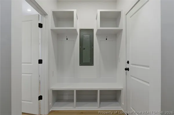 an empty space with wooden floor and white kitchen