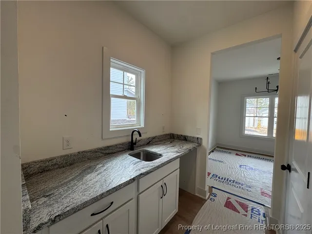 a bathroom with a granite countertop sink and window