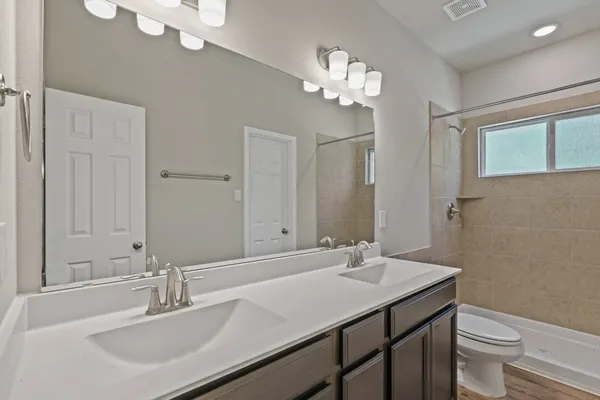 a bathroom with a sink a toilet and a mirror