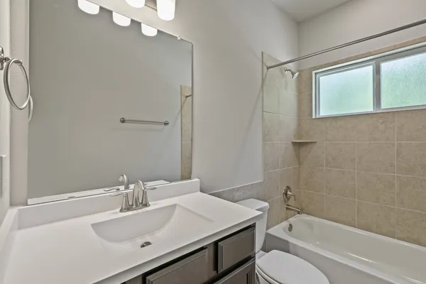 a bathroom with a sink vanity mirror and toilet