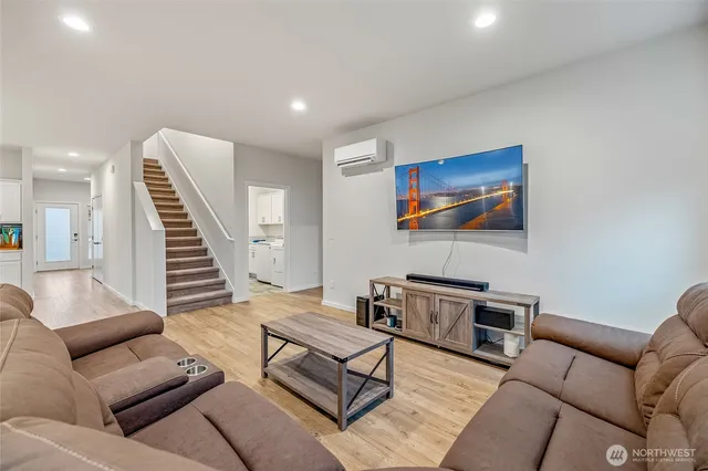 a living room with furniture and a wooden floor