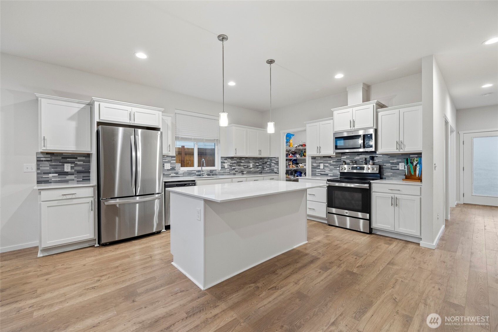 2113 Lancaster Way Ferndale, WA 98248 - Photo 7 of 32 a kitchen with refrigerator a microwave and white cabinets