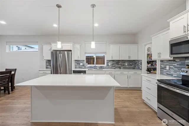 a large kitchen with kitchen island a sink stainless steel appliances and cabinets