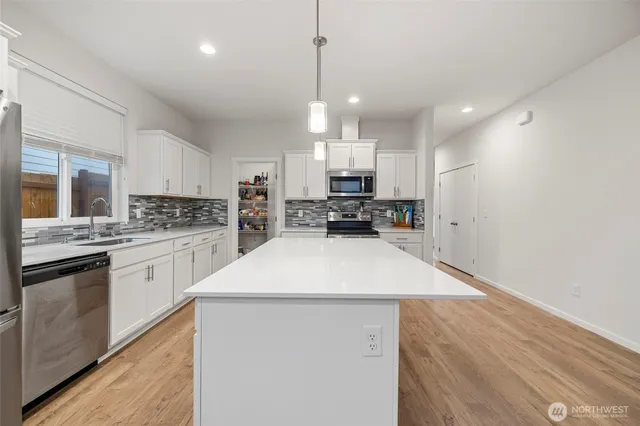 a kitchen with stainless steel appliances a refrigerator sink and stove