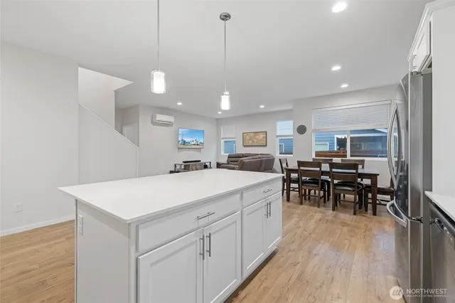 a large white kitchen with lots of counter space and chairs