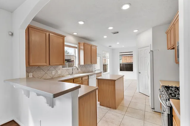 a kitchen with a sink a counter top space and stainless steel appliances