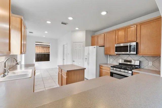 a kitchen with stainless steel appliances a refrigerator stove microwave and sink