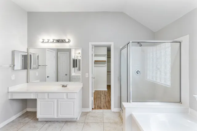a bathroom with a sink tub shower and a mirror