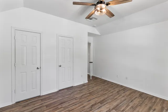 a view of a room with wooden floor and ceiling fan