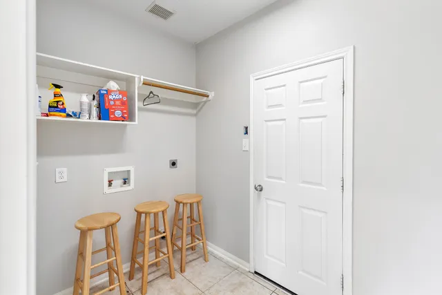 a view of a hallway with table and chairs