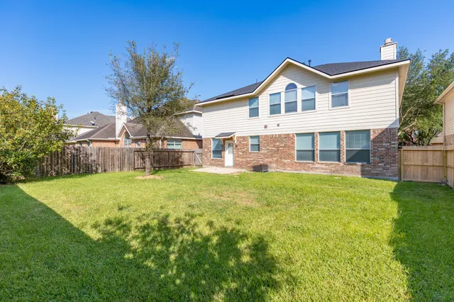 a front view of a house with a yard and potted plants