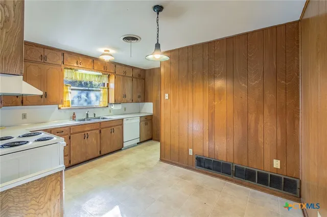 a kitchen with granite countertop cabinets stainless steel appliances a sink and a window