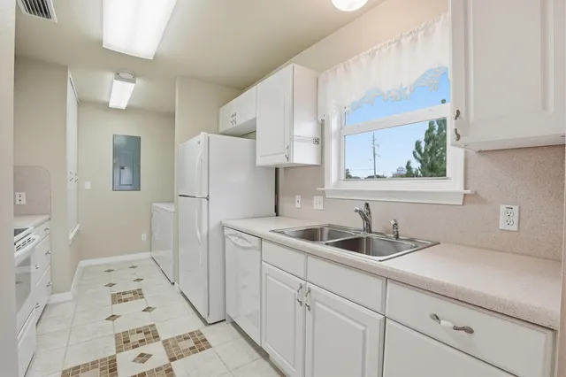 a view of swimming pool with lawn chairs and large trees