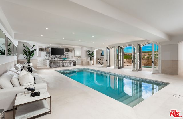 a large white kitchen with a large counter top sink and stainless steel appliances