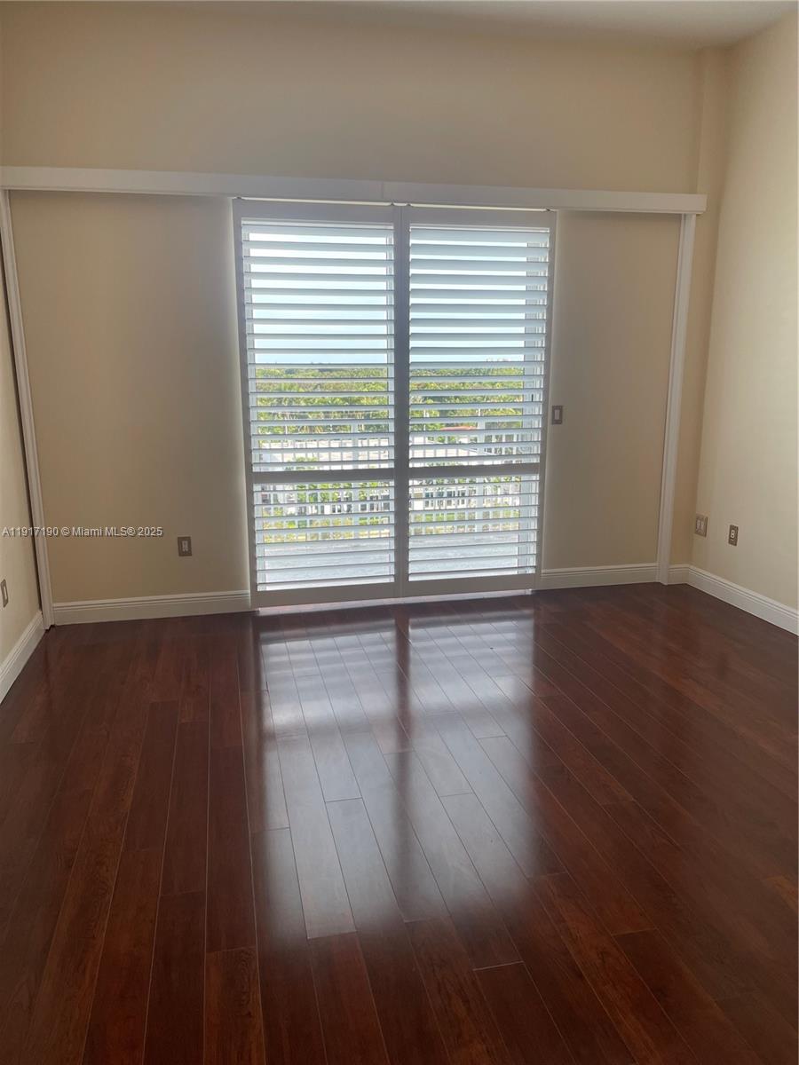7280 Southwest 90th Street, Unit 708 Miami, FL 33156 - Photo 5 of 18 a view of empty room with wooden floor and fan